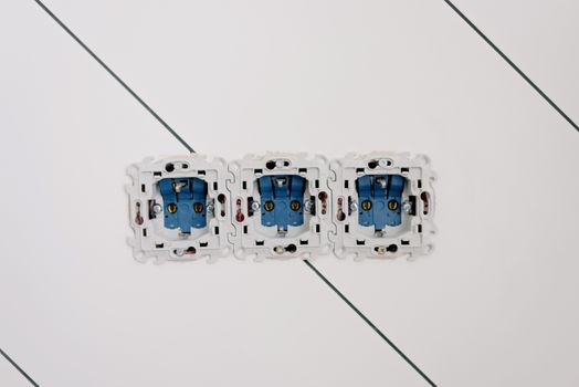 Power sockets with various connectors and bolts on wall in room at home