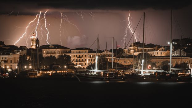 A striking view of a thunderstorm illuminating the harbor and cityscape of Corfu, Greece.